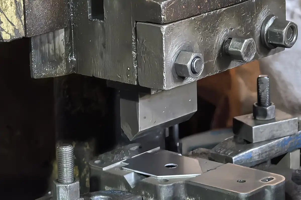 Close-up of stamping press die tooling during metal stamping operation, precision mold cavity visible in high-tonnage press