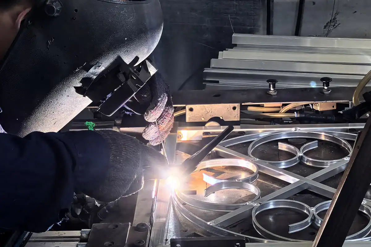 Professional TIG welder performing precision welding on metal assembly in clean fabrication environment