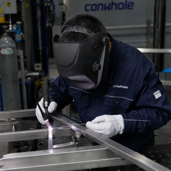Certified welder executing precision TIG welding on modular 3D fixture table at Conwhole